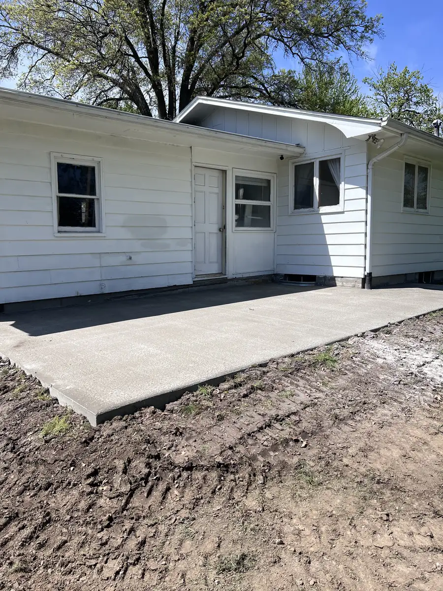 Finished concrete patio slab behind a white house
