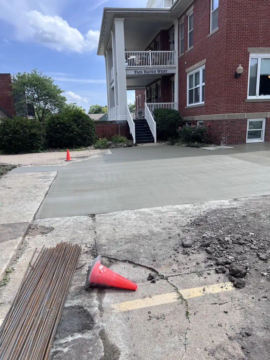 Fresh concrete pour at a brick apartment building with rebar stacked nearby