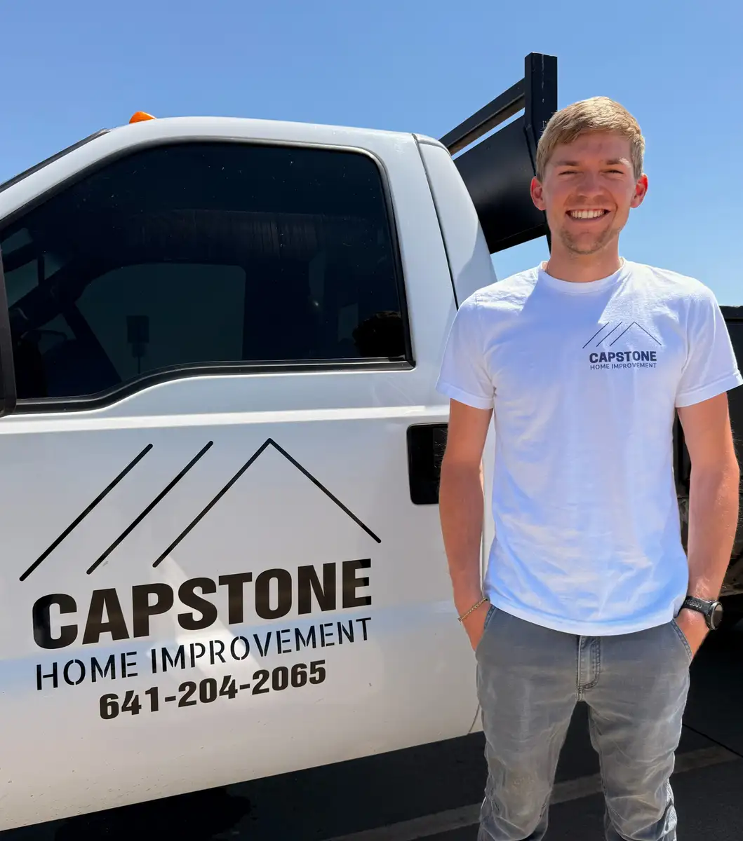 Clayton Henry of Capstone Home Improvement standing by the company truck