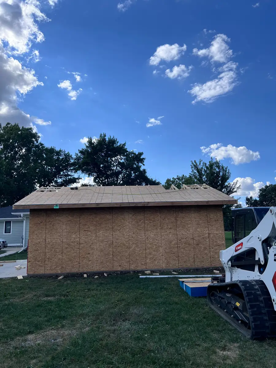 New shed built on a prepared site, with a Bobcat parked beside it